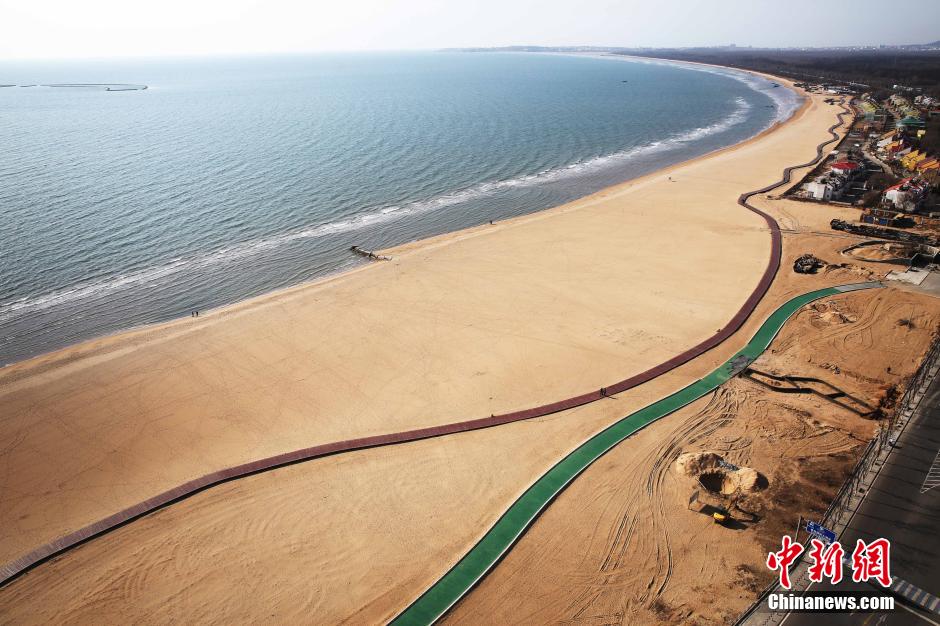 3月13日，秦皇島萬(wàn)米臨海沙灘木棧道。據了解，該木棧道全長(cháng)約4200米，與北戴河區原有的7500米木棧道對接后全線(xiàn)總長(cháng)度1.17萬(wàn)米，整個(gè)木棧道東起秦皇島體育基地游船碼頭，西至北戴河濕地公園，呈波浪形蜿蜒10.4公里海岸線(xiàn)。 中新社發(fā) 曹建雄 攝 CNSPHOTO