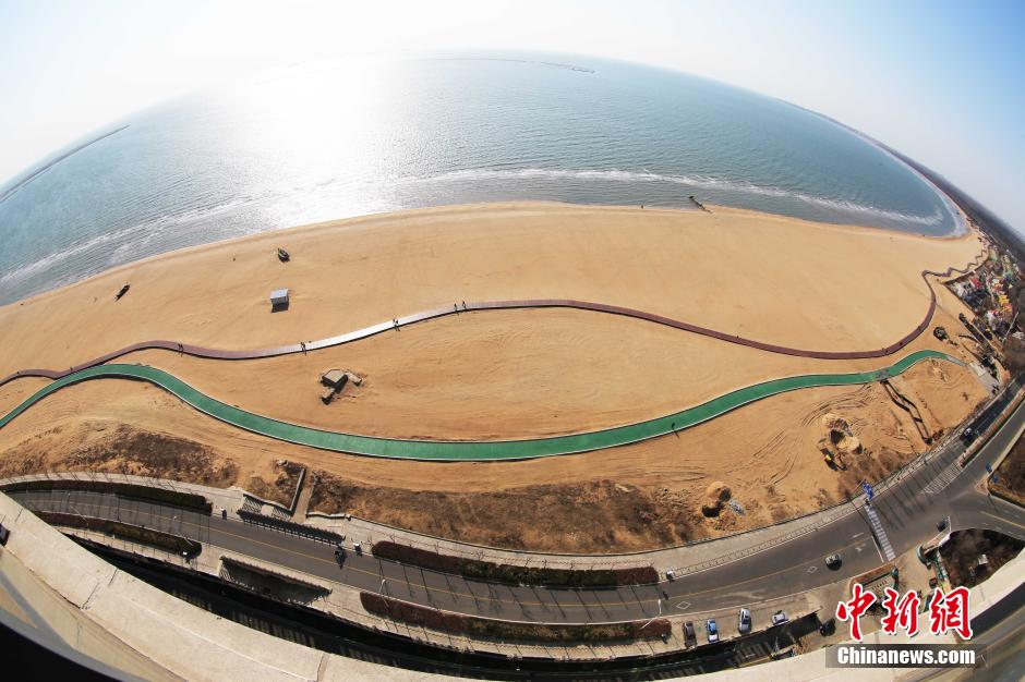 3月13日，秦皇島萬(wàn)米臨海沙灘木棧道。據了解，該木棧道全長(cháng)約4200米，與北戴河區原有的7500米木棧道對接后全線(xiàn)總長(cháng)度1.17萬(wàn)米，整個(gè)木棧道東起秦皇島體育基地游船碼頭，西至北戴河濕地公園，呈波浪形蜿蜒10.4公里海岸線(xiàn)。 中新社發(fā) 曹建雄 攝 CNSPHOTO